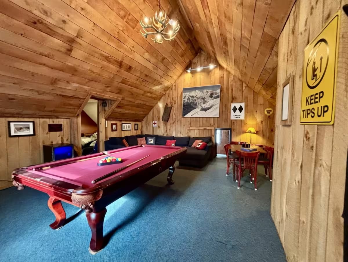 Game room at 56 Main Street with pool table, vaulted wood ceiling, and mountain-lodge seating